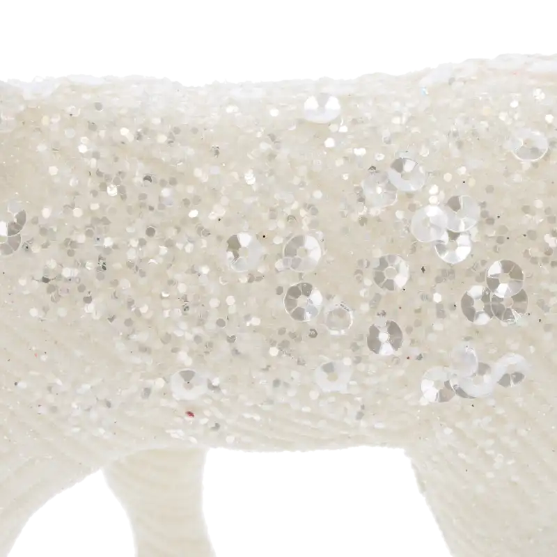 Makro zdjęcie powierzchni figurki renifera, ukazujące strukturę brokatu oraz precyzyjnie rozmieszczone cekiny na tworzywie.