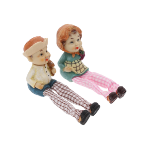 Figurki babci i dziadka ustawione obok siebie, widoczne z boku. Postacie posiadają zwisające nogi, co pozwala na umieszczenie ich na brzegu mebla.