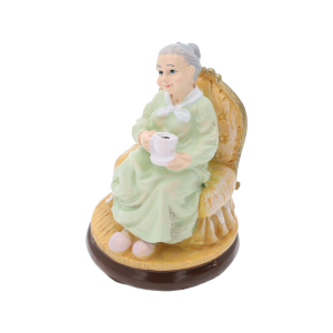 Prezentacja figurki babci z filiżanką z perspektywy bocznej, ukazująca detale ubioru i fotela.