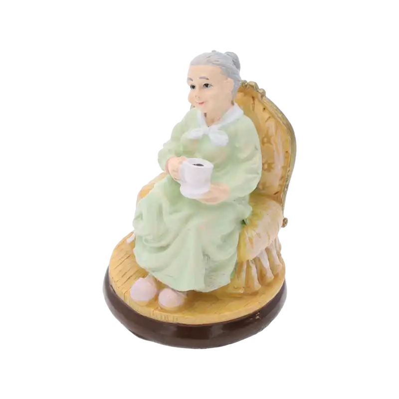 Prezentacja figurki babci z filiżanką z perspektywy bocznej, ukazująca detale ubioru i fotela.