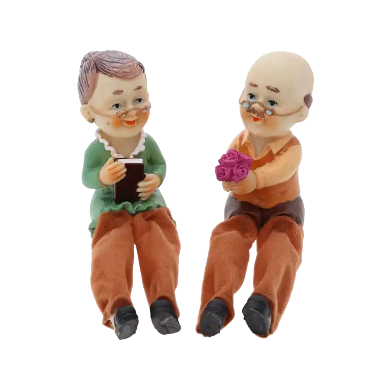 Figurki dziadek i babcia 10 cm z materiałowymi nogawkami. Zestaw 2 sztuk, w którym dziadek wręcza kwiaty babci czytającej książkę.