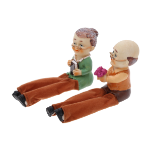 Widok z profilu na figurki babci i dziadka 10 cm. Postacie siedzą obok siebie, dziadek trzyma bukiet róż, babcia trzyma książkę.