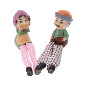 Figurki babci i dziadka w pozycji siedzącej, ukazujące różnice w kolorystyce ich strojów i wyrazie twarzy.