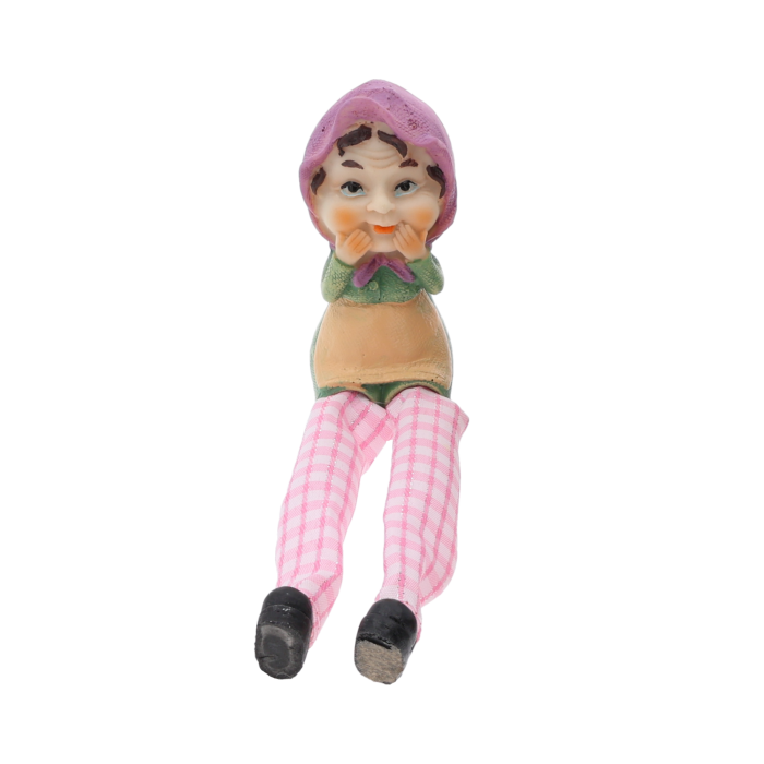 Figurka babci o wysokości 9 cm z luźno opadającymi nogawkami w różową kratkę. Prezentuje uroczy design z tkaniny i tworzywa, idealna jako ozdoba wnętrza.