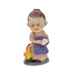 Figurka babcia karmiąca kurę o wysokości 15 cm. Prezentuje starszą panią w okularach i fioletowym fartuchu, trzymającą koszyk. Urocza dekoracja wnętrza.