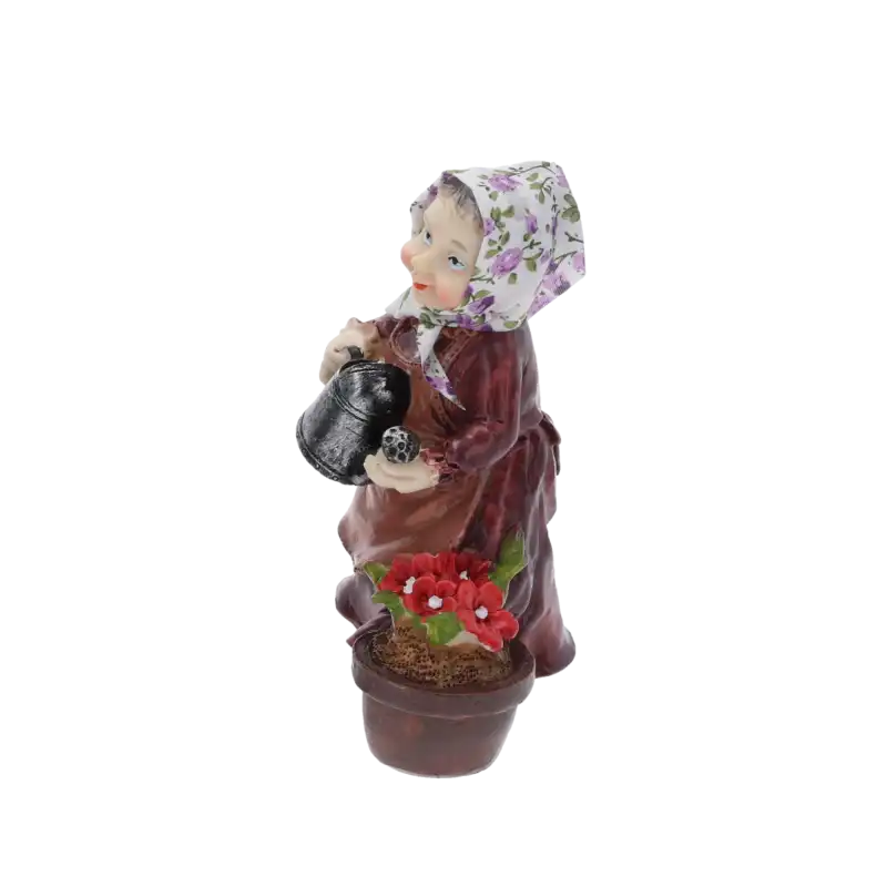 Figurka babcia z konewką widziana pod kątem. Ujęcie eksponuje wyraz twarzy, chustkę z tkaniny oraz kwiaty w doniczce. Dekoracja 15 cm pasująca do różnych stylów wnętrz.