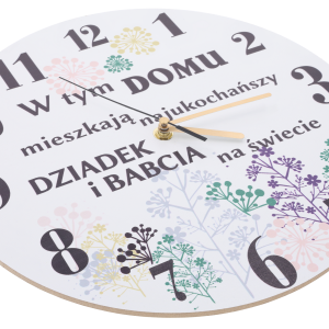 Zbliżenie na tarczę zegara pod kątem, ukazujące nadruk dedykacji, kwiatowe zdobienia oraz wskazówki czasomierza.