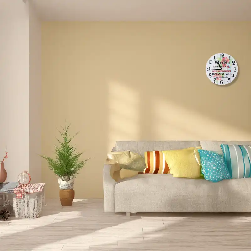 Zegar 30 cm zawieszony na jasnej ścianie w salonie nad kanapą z kolorowymi poduszkami.