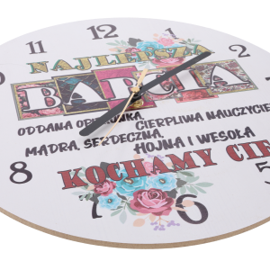 Zbliżenie na tarczę zegara z MDF pod kątem, ukazujące czarne wskazówki oraz szczegóły nadruku z dedykacją dla babci.