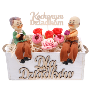 Biała skrzynka Dla Dziadków z figurkami dziadków, wypełniona sztucznymi kwiatami i topperem z napisem Kochanym Dziadkom.
