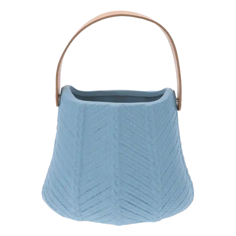 Ceramiczna osłonka w kształcie torebki w kolorze niebieskim. Dekoracyjne boki z wytłoczonym wzorem oraz skórzany uchwyt tworzą unikalny design dekoracji.