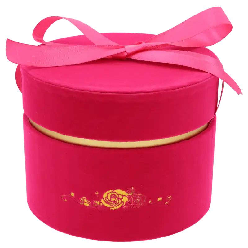 Różowy flower box o średnicy 17 cm. Welurowe pudełko posiada elegancki złoty nadruk, pasującą wstążkę oraz pokrywkę, tworząc luksusową oprawę dla każdej kompozycji kwiatowej.