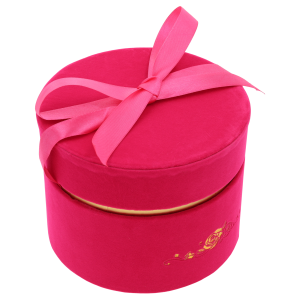 Kątowe ujęcie różowego flower boxa z widoczną satynową wstążką zawiązaną na pokrywce. Welurowa faktura pudełka podkreśla jego elegancki charakter.