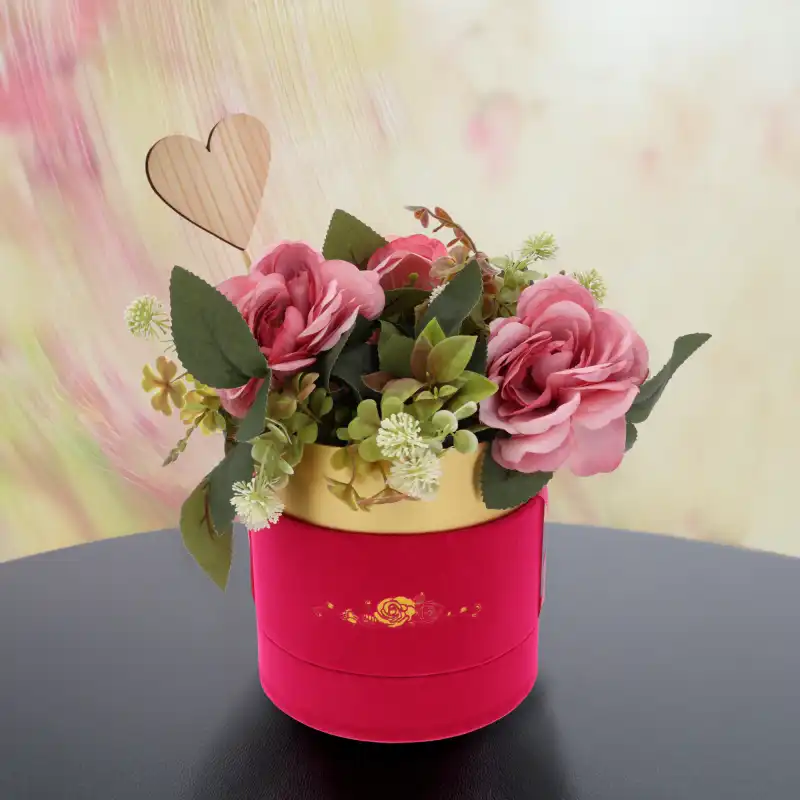 Aranżacja prezentowa przedstawiająca kwiaty w różowym flower boxie. Złoty nadruk na welurowej powierzchni dodaje całości wyrafinowanego stylu.