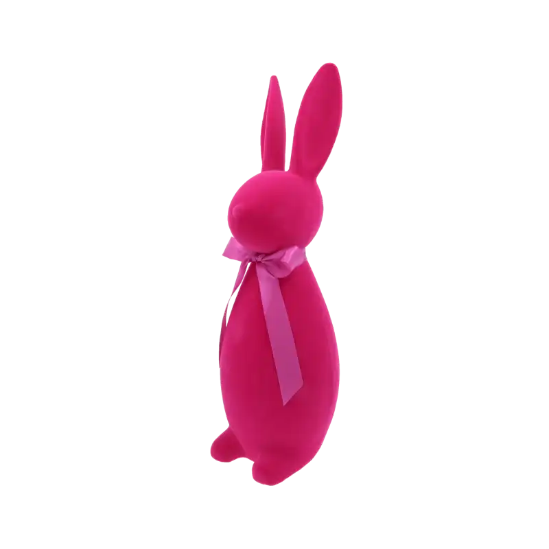 Zbliżenie na formę zająca flokowanego w kolorze fuksji. Widoczny profil figurki z podkreśloną satynową kokardą na szyi, idealny element wiosennej aranżacji.