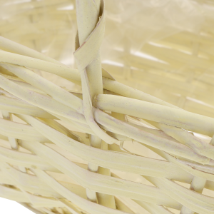 Szczegółowy widok na uchwyt i miejsce łączenia wiklinowych elementów żółtego kosza. Wyraźne zbliżenie na precyzyjny splot naturalnego materiału.