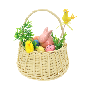 Flokowana kura na piku umieszczona w wiklinowym koszyku wielkanocnym wśród ceramicznego zająca, pisanek i zielonych gałązek dekoracyjnych.