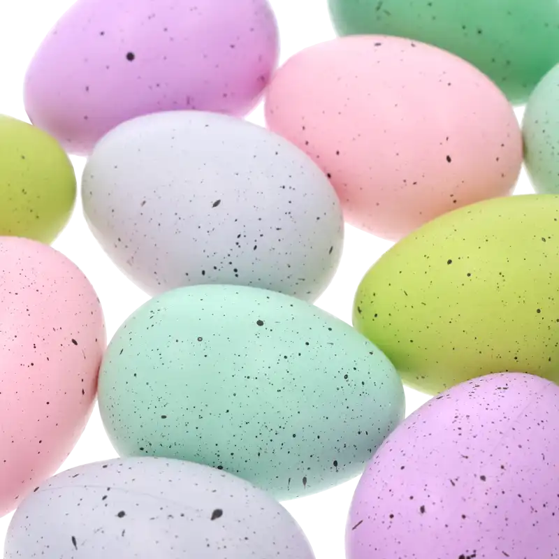 Zbliżenie na powierzchnię wielkanocnych jaj, ukazujące detale pastelowych kolorów z ciemnymi kropkami, idealnych do komponowania świątecznych stroików.