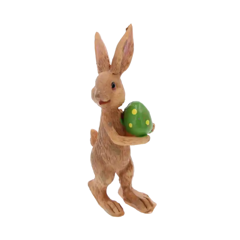 Szczegółowy widok figurki brązowego zajączka trzymającego zieloną pisankę w żółte kropki. Dekoracja wielkanocna o wysokości 9 cm.