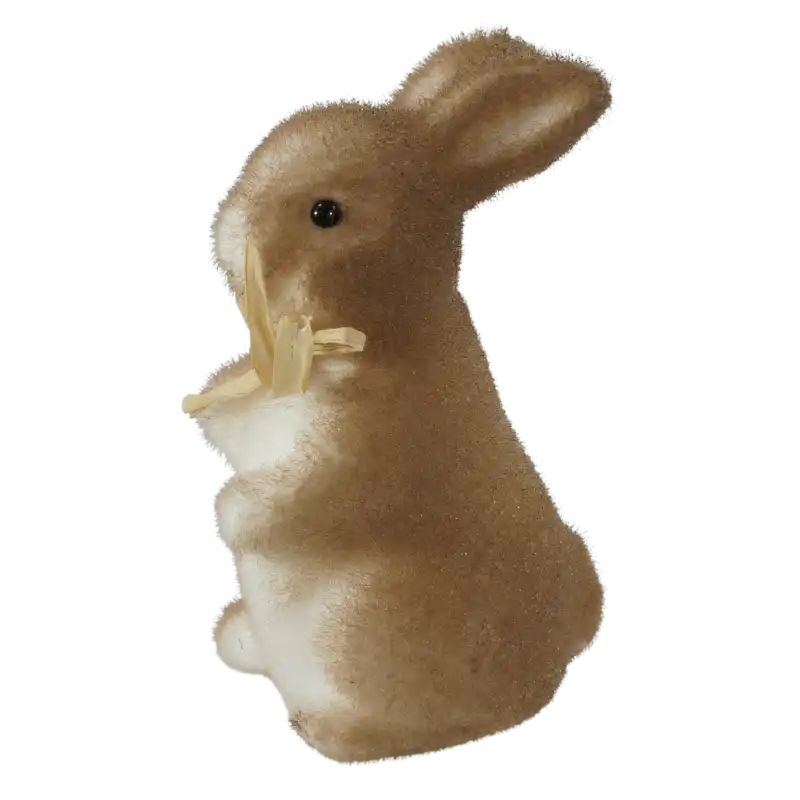 Profil figurki zajączka pokrytej brązowym flokiem. Widoczny kształt uszu, sylwetka oraz ozdobna słomkowa kokarda przewiązana pod szyją dekoracji.