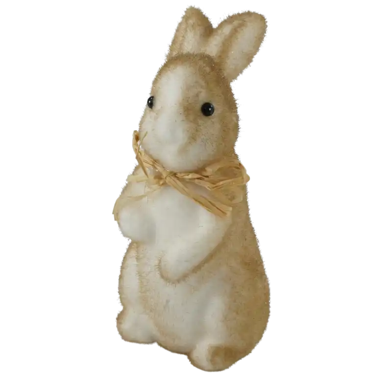 Brązowy flokowany zajączek wielkanocny o wysokości 15 cm. Figurka z drobinkami brokatu i słomkową kokardą, ujęta z profilu, idealna do świątecznych aranżacji.