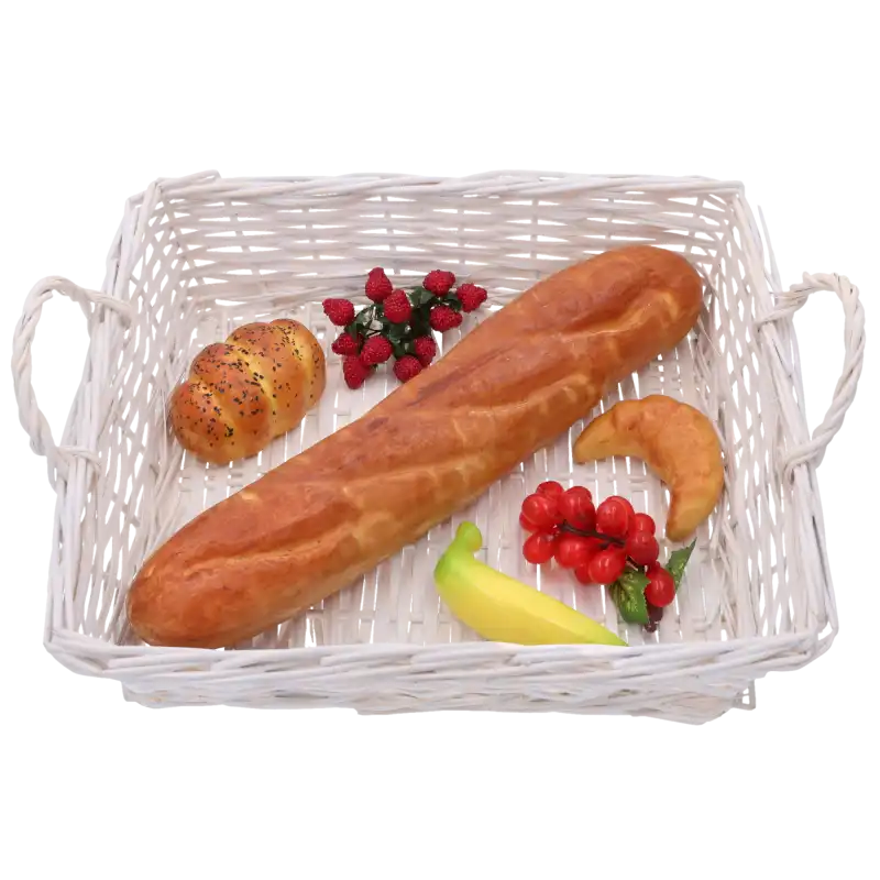 Biały wiklinowy kosz wypełniony sztucznym pieczywem i owocami. Przykład praktycznego zastosowania kosza w kuchni lub jadalni.