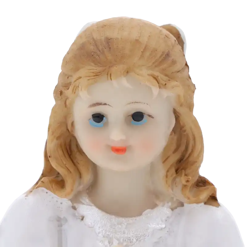 Szczegółowy portret twarzy figurki dziewczynki komunijnej. Widoczne delikatne rysy i jasne włosy.