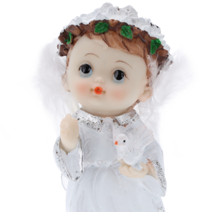 Portretowe zbliżenie na twarz figurki aniołka, prezentujące rysy postaci, wianek oraz trzymanego w dłoniach gołębia.