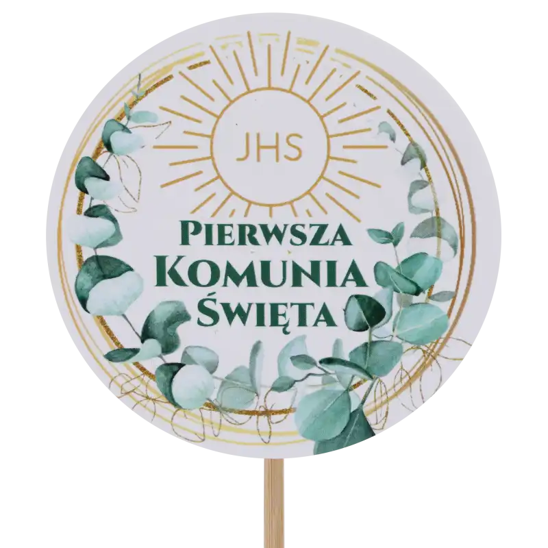Zbliżenie na topper komunijny z eukaliptusem o średnicy 7 cm. Okrągły wzór z napisem Pierwsza Komunia Święta i motywem roślinnym.