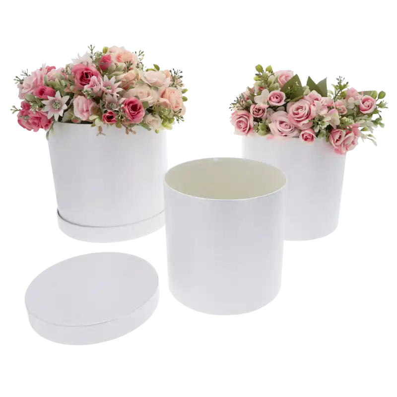 Dwa białe flower boxy wypełnione kwiatami oraz jedno puste pudełko z pokrywką obok, idealne na podziękowanie.