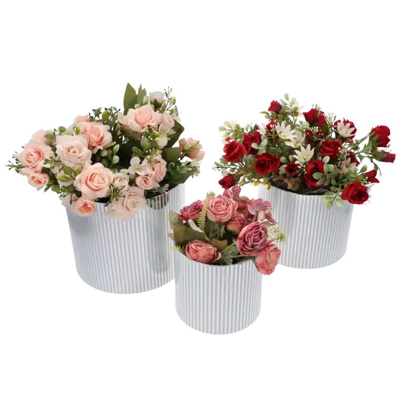 Trzy srebrne flower boxy w paski wypełnione różnorodnymi kompozycjami kwiatowymi w odcieniach różu i czerwieni.