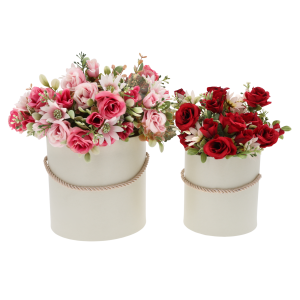 Dwa kremowe flower boxy wypełnione różnorodnymi sztucznymi kwiatami w odcieniach różu i czerwieni. Zestaw stanowi gotową inspirację na elegancką dekorację wnętrza lub upominek na różne okazje.