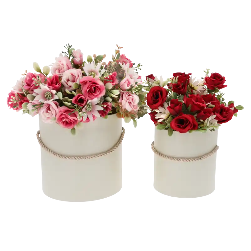 Dwa kremowe flower boxy wypełnione różnorodnymi sztucznymi kwiatami w odcieniach różu i czerwieni. Zestaw stanowi gotową inspirację na elegancką dekorację wnętrza lub upominek na różne okazje.