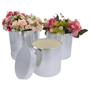 Aranżacja kwiatowa wewnątrz dwóch srebrnych flower boxów, obok widoczne puste pudełko z odłożoną pokrywką.