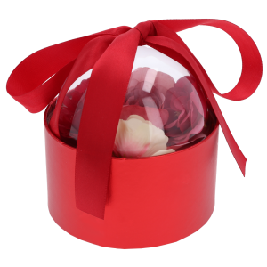 Czerwony flower box z przezroczystą pokrywką zawierający różowe kwiaty. Artykuły dekoracyjne w kształcie półkuli o średnicy 13 cm z wstążką.