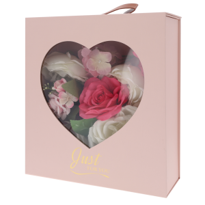 Różowy składany flower box o wymiarach 30x25x10 cm z okienkiem w kształcie serca, wypełniony kwiatami i napisem Just For You.