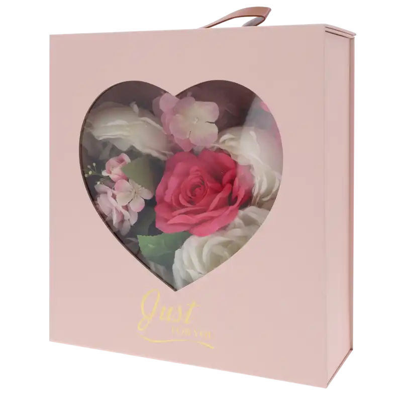 Różowy składany flower box o wymiarach 30x25x10 cm z okienkiem w kształcie serca, wypełniony kwiatami i napisem Just For You.