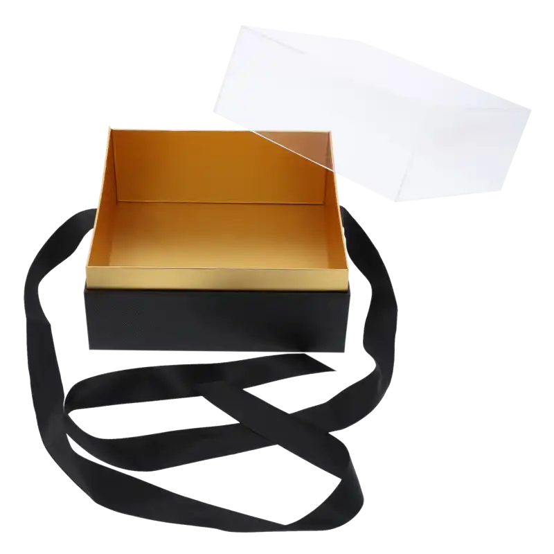 Czarny flower box o wymiarach 20x20 cm ze zdjętą przezroczystą pokrywką, ukazujący złote wnętrze pudełka i długą czarną wstążkę.