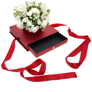 Czerwony flower box z szufladą, w którym umieszczono bukiet białych róż, prezentujący sposób wykorzystania dekoracji.