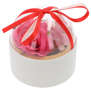 Welurowy flower box w kolorze białym wypełniony kwiatami, zamknięty przezroczystą półkulą. Całość przewiązana jest ozdobną wstążką.