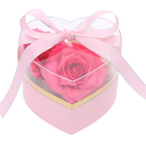 Różowy flower box z przezroczystą pokrywką, wewnątrz wypełniony kompozycją z różowych kwiatów. Elegancka dekoracja.