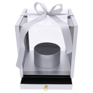 Srebrny flower box o wymiarach 25x25 cm z przezroczystymi ściankami, ozdobną kokardą i wysuwaną szufladą. Pudełko posiada okrągłą osłonkę na kwiaty.