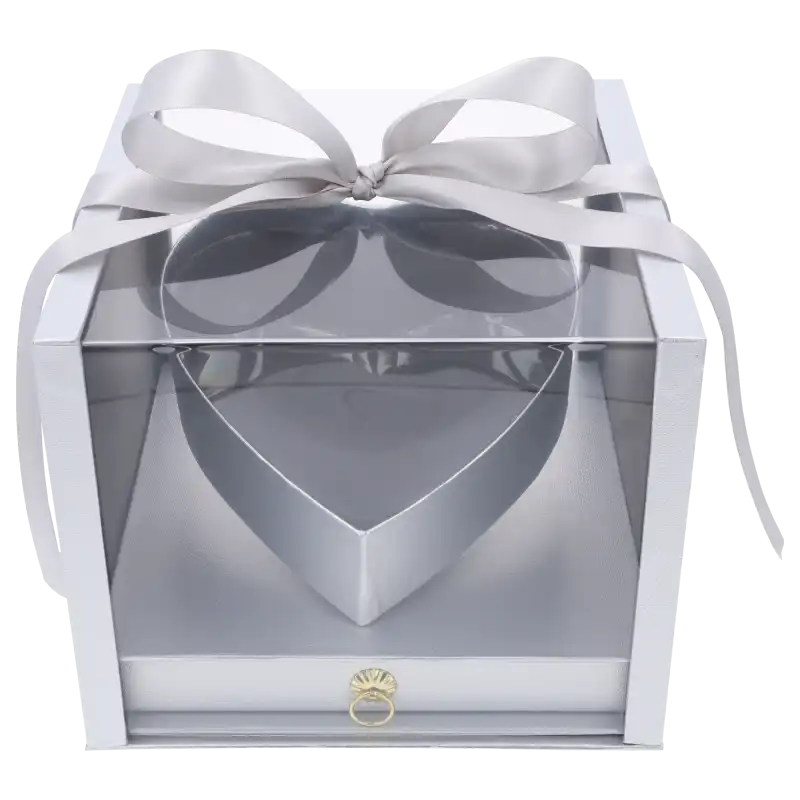 Srebrny flower box serce z szufladą o wymiarach 23x23 cm. Pudełko posiada przezroczyste ścianki i górę, wykończone dekoracyjną kokardą.