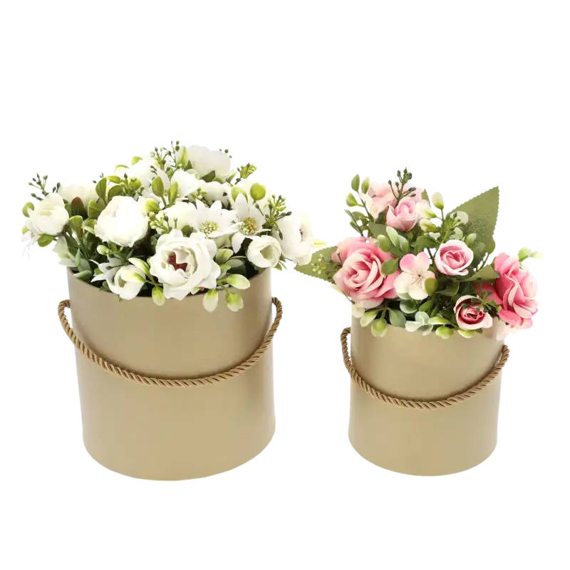 Dwa beżowe flower boxy wypełnione sztucznymi kwiatami w odcieniach bieli i różu. Eleganckie opakowanie, które sprawdzi się jako prezent.