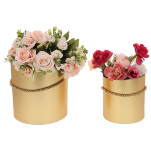 Złote flower boxy wypełnione różnymi kwiatami. Estetyczna kompozycja prezentowa podkreślająca funkcjonalność zestawu.