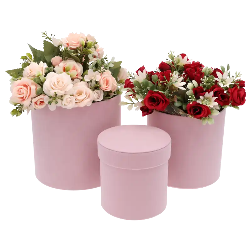 Aranżacja z dwoma różowymi welurowymi flowerboxami wypełnionymi sztucznymi kwiatami w odcieniach różu i czerwieni.