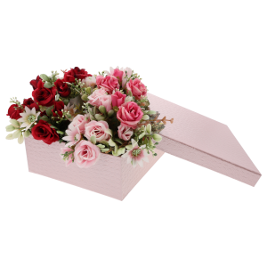 Różowy flower box wypełniony kompozycją kwiatową z czerwonych i różowych sztucznych róż, obok leży zdjęta pokrywka.