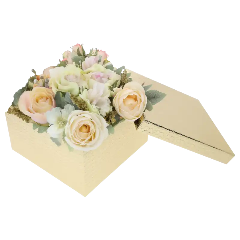 Złoty kwadratowy flower box z kompozycją kwiatową w pastelowych odcieniach. Obok pudełka leży dopasowana pokrywka, podkreślająca funkcjonalność zestawu.