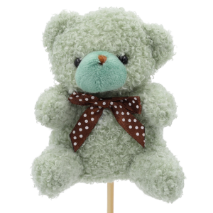 Zbliżenie na pluszowego zielonego misia na piku o wysokości 35 cm, ozdobionego elegancką brązową kokardą w białe kropki. Idealny topper do bukietów.