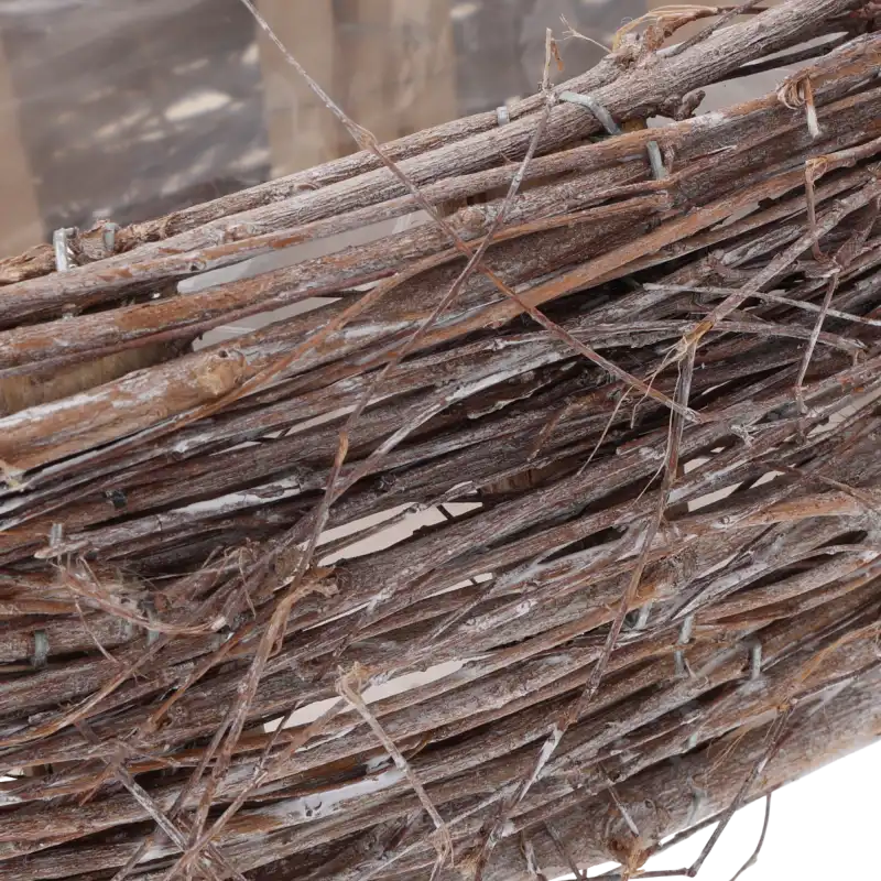 Zbliżenie na fakturę drewnianych gałązek tworzących ścianki kosza, ukazujące naturalny materiał wykonania.